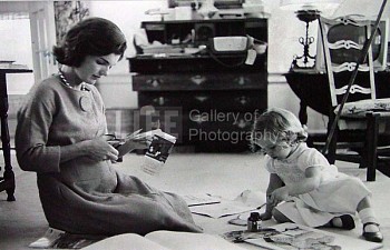 Alfred Eisenstaedt -&nbsp;Alfred Eisenstaedt Jacqueline Kennedy, Wife of Senator with Scissors Cutting Out Newspaper Clippings Next to Open Scrapbook as Her Young Daughter Caroline Toys with the Applicator from a Glue Bottle, At Home, Hyannis Port, MA