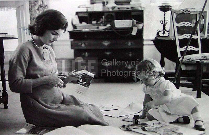 Alfred Eisenstaedt, Jacqueline Kennedy, Wife of Senator with Scissors Cutting Out Newspaper Clippings Next to Open Scrapbook as Her Young Daughter Caroline Toys with the Applicator from a Glue Bottle, At Home, Hyannis Port, MA, 1960
Vintage Silver Gelatin Print, 7 3/4 x 9 inches